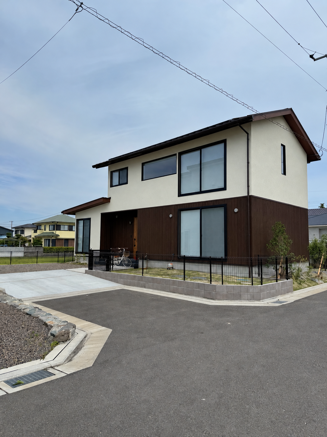 木目の住宅に調和するフェンスと植栽